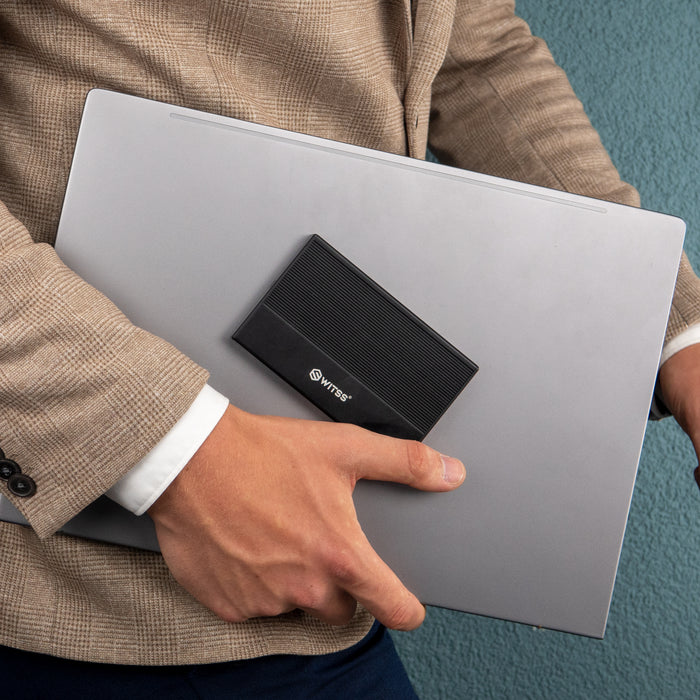 Persoon draagt een laptop met de zwarte behuizing erbovenop