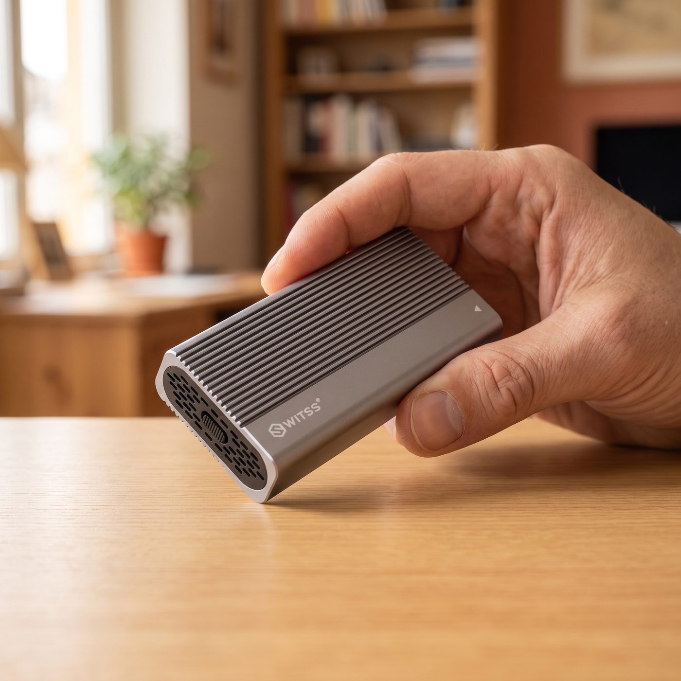 Hand houdt de Switss® USB4 M.2 behuizing vast, toont het compacte formaat