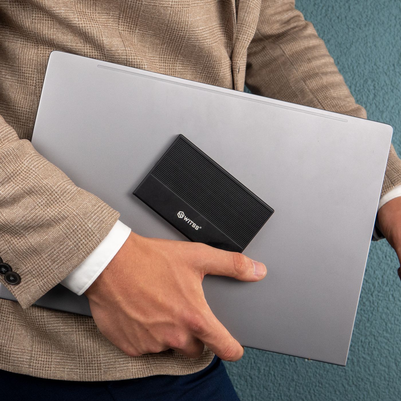 Black Switss enclosure on a laptop under someone's arm