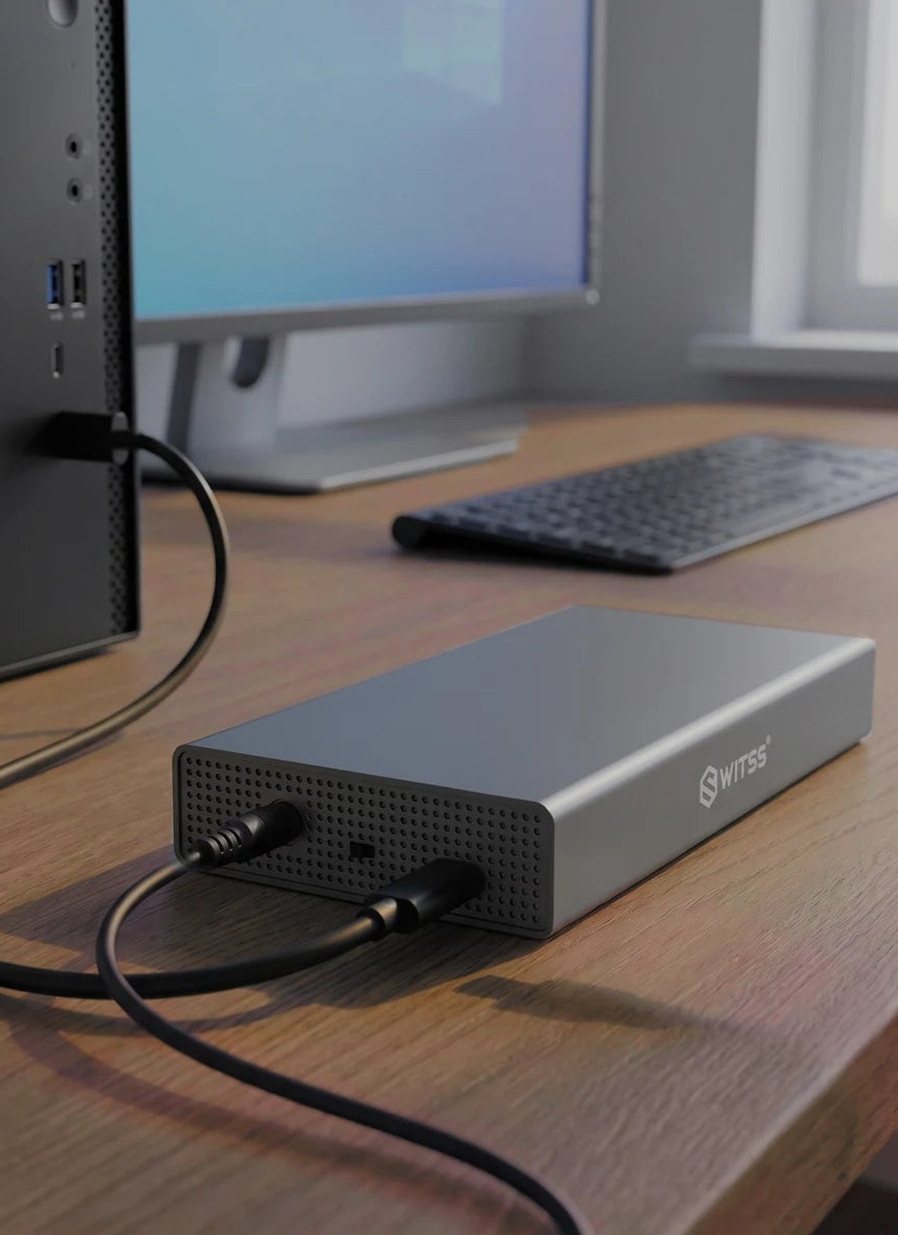 Boîtier HDD 3,5 pouces Switss® connecté à un PC de bureau sur un bureau en bois