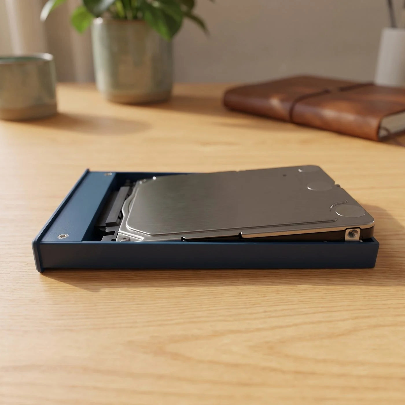 The open Switss 2.5 inch enclosure on a wooden desk, with a bare 2.5 inch drive on the frame