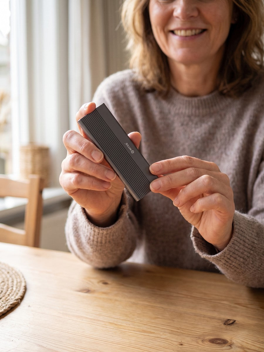 Vrouw houdt de Switss M.2-behuizing vast, aluminium cooling fins zichtbaar